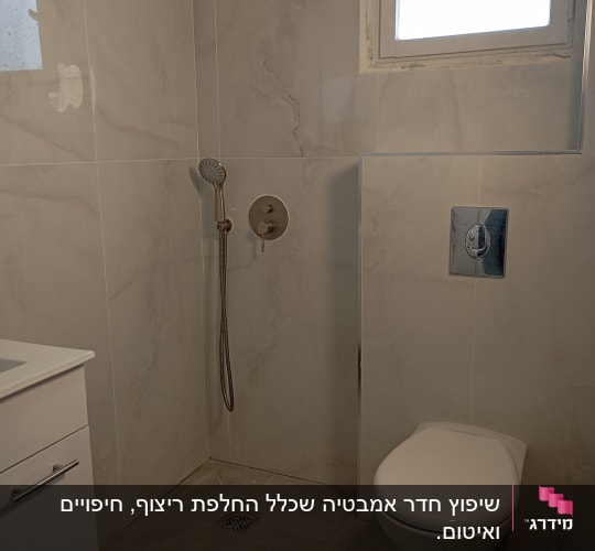 חדר אמבטיה משופץ עם מקלחון ואסלה